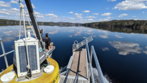 LEA Staff Limnologist Maggie Welch on board buoy boat as it approaches Long Lake deployment site.