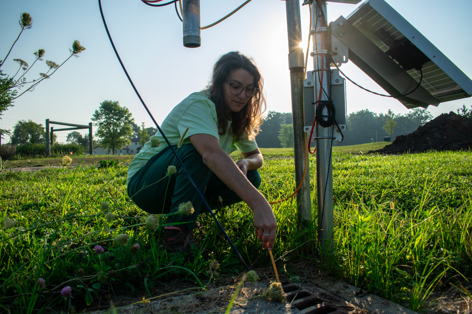 Katelyn Kubasky deploying the WLTS in the pond weir after integration with the X3 data logger.