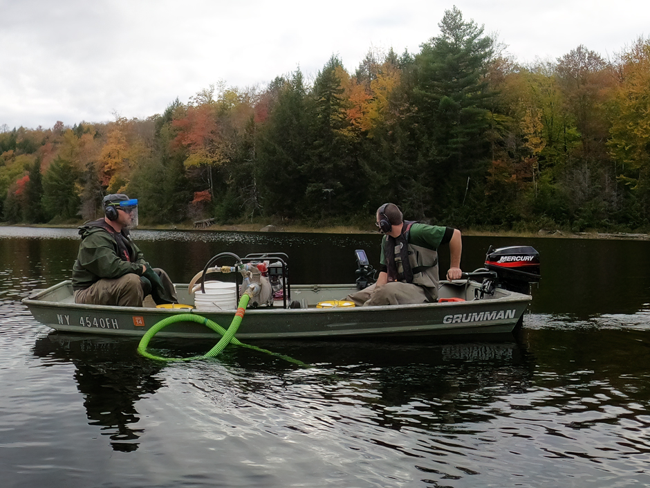 Fish and Wildlife Technician Dustin Dominesey in bow and Fish and Wildlife Technician Adam Kosnick in back of boat conducting a reclamation on Murphy Lake in Adirondack Park in 2021