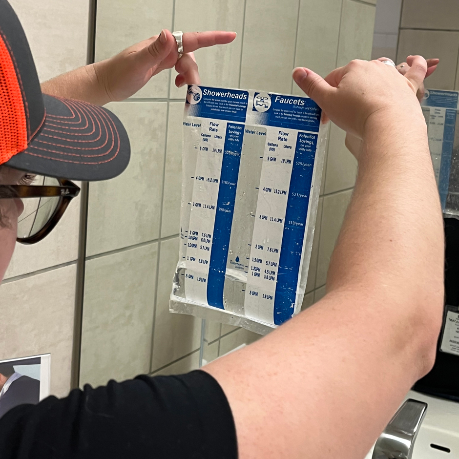  Team member measures water flow in a sink to determine its average water use