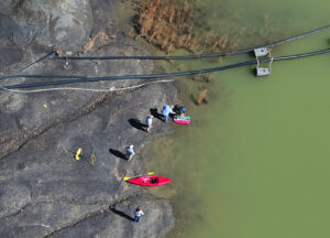 DOW bathymetry team assisting Abandoned Mine Lands in collecting depth/volume data at a coal pond retention basin. The image is take from above with a drone