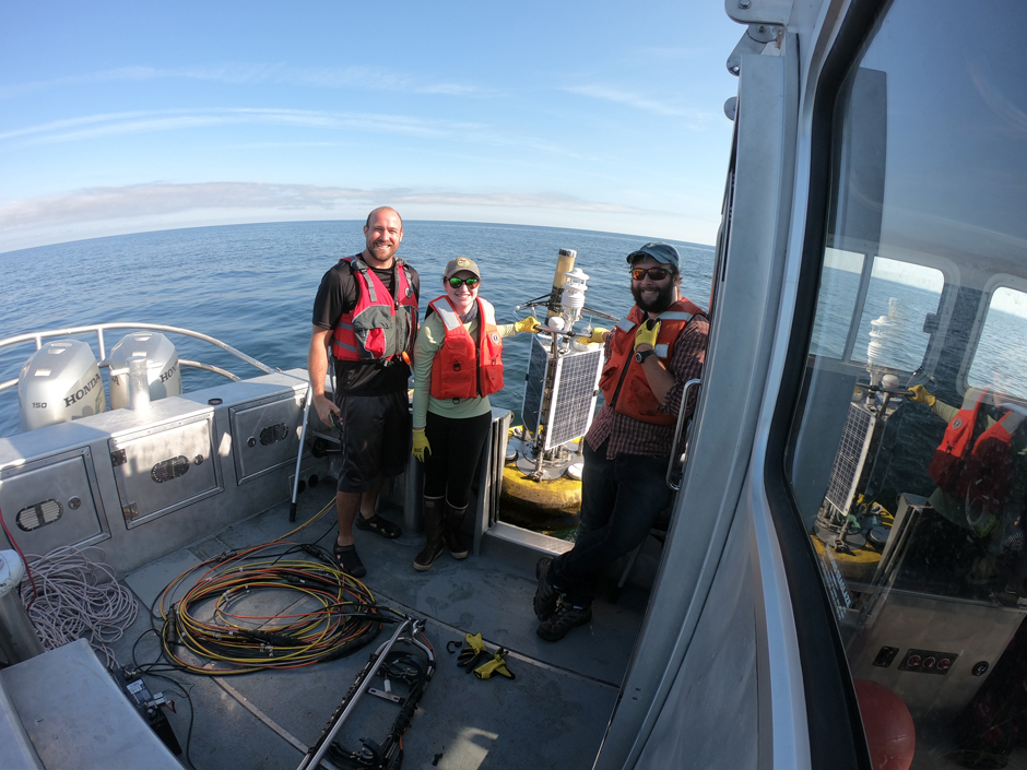 Brian Haas, Emily Klimczak, and Ben Szczygiel retrieving the CB-650 data buoy in early fall and preparing to tow it back to shore. 