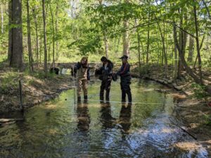 HRWC citizen science volunteers measure stream velocity across a subsection of Woods Creek, a tributary of the Huron River near Belleville, Michigan.