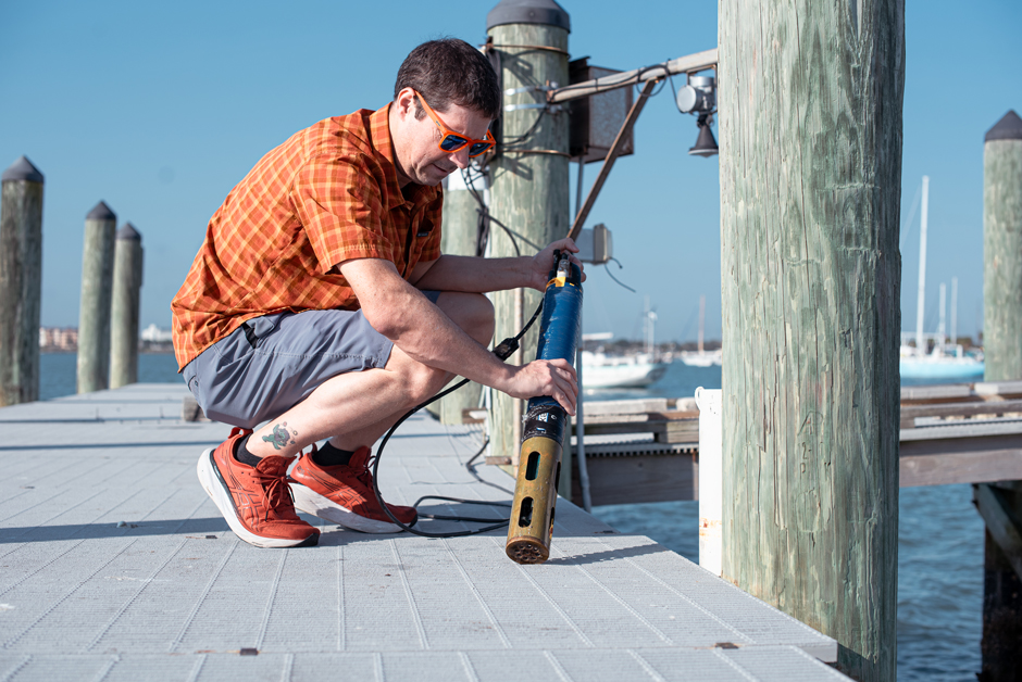 Janiak deploying a YSI EXO2 at the doc outside of the MarineGEO station.