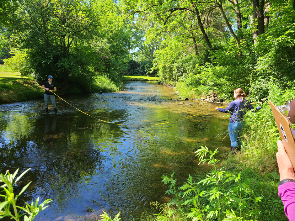 Noelle Cudney and Amanda Goldsmith demonstrating stream measurements for water quality monitoring volunteers.